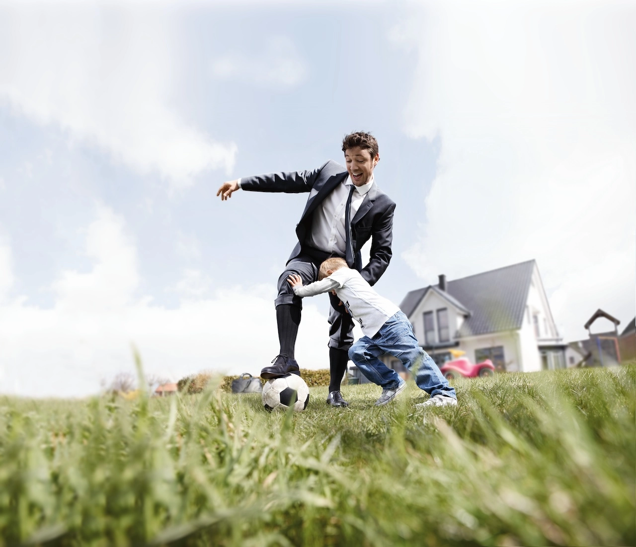Vater und Sohn spielen Fussball und tragen Kompressionsstruempfe