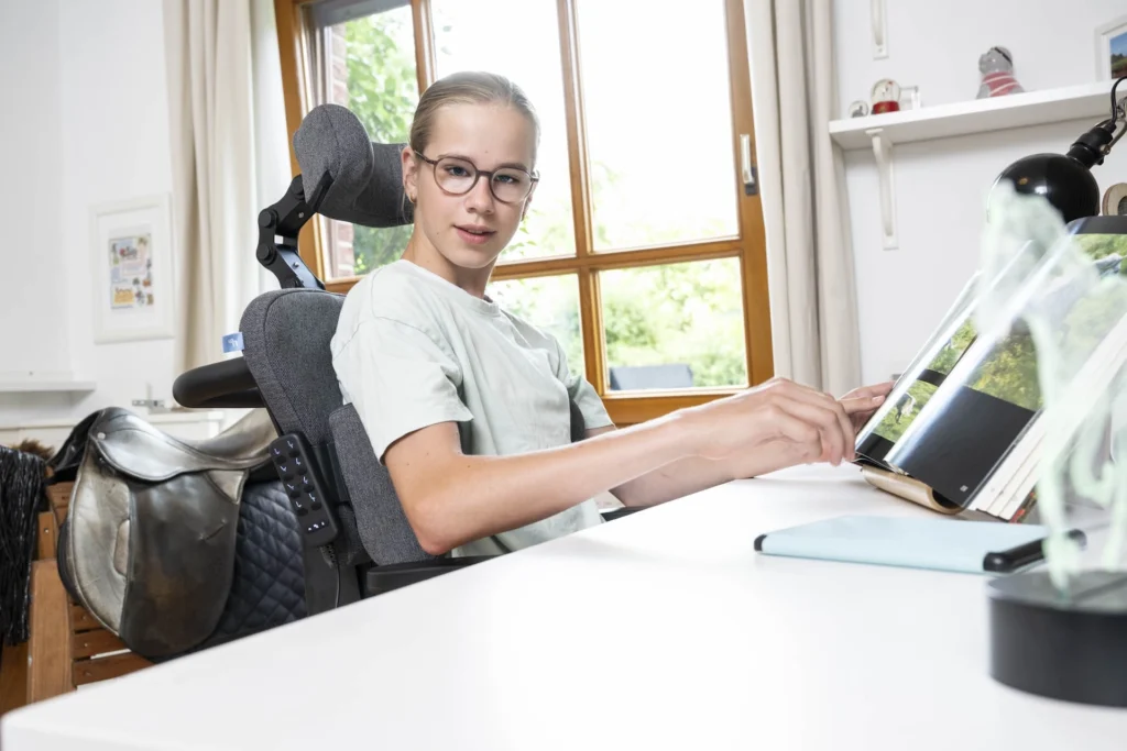 Maedchen sitzt in orthopaedischem Stuhl